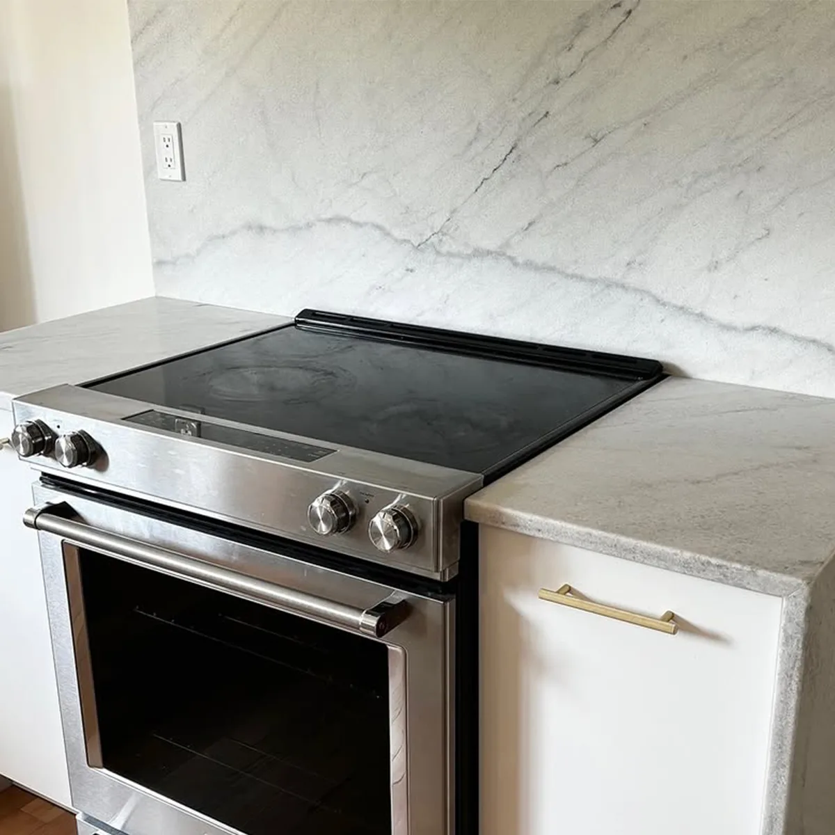 A luxurious kitchen featuring Smokey White Marble countertops and backsplash, with soft white tones, smoky gray veining, and elegant lighting.