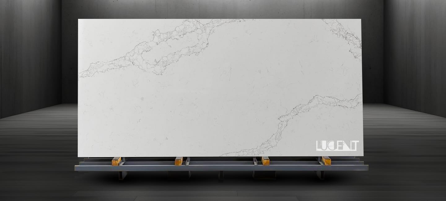 A large slab of Smokey White Marble displayed on a sturdy stand, featuring soft white tones and smoky gray veining in a well-lit showroom.