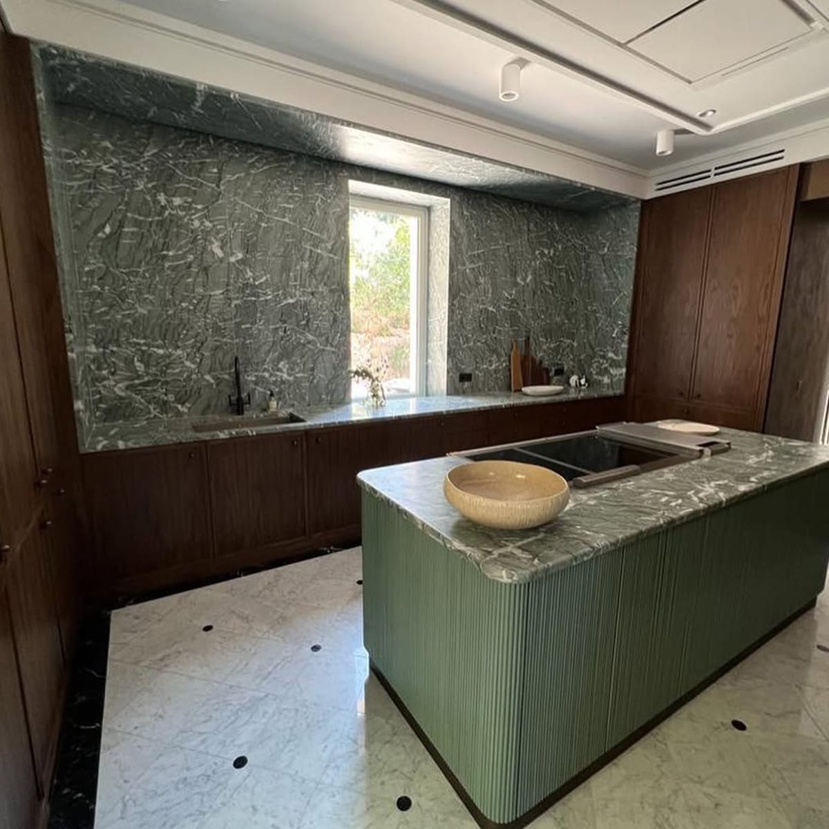 Verde Antigua Marble used on kitchen island and countertop in a modern green-toned interior