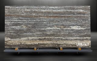 Silver Travertine slab displayed on a holder, showcasing its natural silver-gray veining and texture.