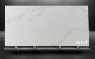 Smokey White Marble Slab | Premium Natural Stone Display A large slab of Smokey White Marble displayed on a sturdy stand, featuring soft white tones and smoky gray veining in a well-lit showroom.
